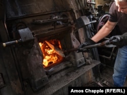 Miralem Oderovic shovels brown coal into the firebox of a kriegslok.