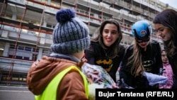 Dea Durmishi (left) and a few of her superhero colleagues bring gifts.