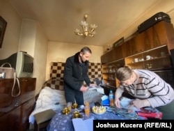 Andranik Vanian and Lusine Stepanian in their new apartment in Yerevan. They are going through old photos that they took with them from their home in Kochoghot, Nagorno-Karabakh.