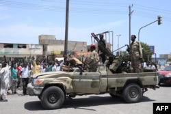 Sudanese greet soldiers loyal to army chief Abdel Fattah al-Burhan in the Red Sea city of Port Sudan on April 16.