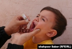 An Afghan health-care worker gives a polio vaccine to a child in the western city of Herat.