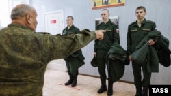 Russian conscripts try on uniforms at a local draft office before departing for military service. (file photo)