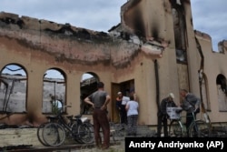 Residents receive humanitarian aid from volunteers in front of the Evangelical Christian Baptist prayer house that was destroyed by a Russian attack in Orikhiv, Zaporizhzhya region, Ukraine.