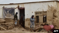 Afghan men clear debris and mud from a damaged house after a flash flood caused by heavy rainfall in Laqiha village of Baghlan-e Markazi district in the northern Baghlan Province on May 11.