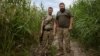 Ukrainian soldiers Rostyslav (left) and Oleksandr patrol the riverbank in Prymorske.