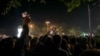 A Bishkek police official tries to calm protesters near a dorm for foreign students in the Kyrgyz capital on the night of May 17-18.