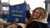 A passenger holds a tote bag that reads #WithoutVisa as Kosovars began to travel to the Schengen Area without a visa for the first time, at the airport in Pristina on January 1.
