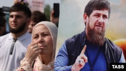 A woman holds a portrait of Chechen strongman Ramzan Kadyrov during a rally staged in Grozny on May 23 after a citizen of Volgograd burned the Koran in front of a mosque.