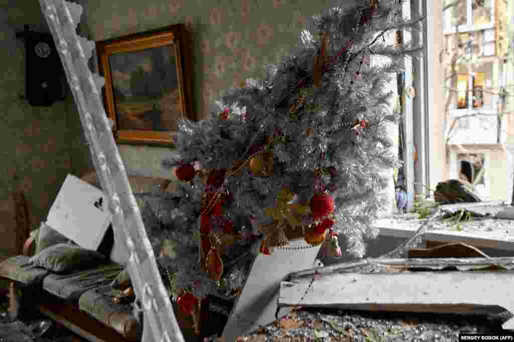 A Christmas tree leans precariously inside a damaged apartment in Kharkiv.