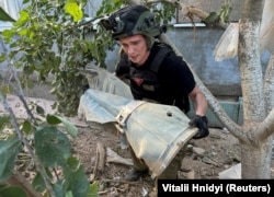 A Ukrainian bomb squad officer carries part of a Russian glide bomb near a private home hit by a Russian air strike in Kharkiv in June.