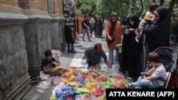 People buy slippers from a street vendor at the Grand Bazaar in Tehran. (file photo)