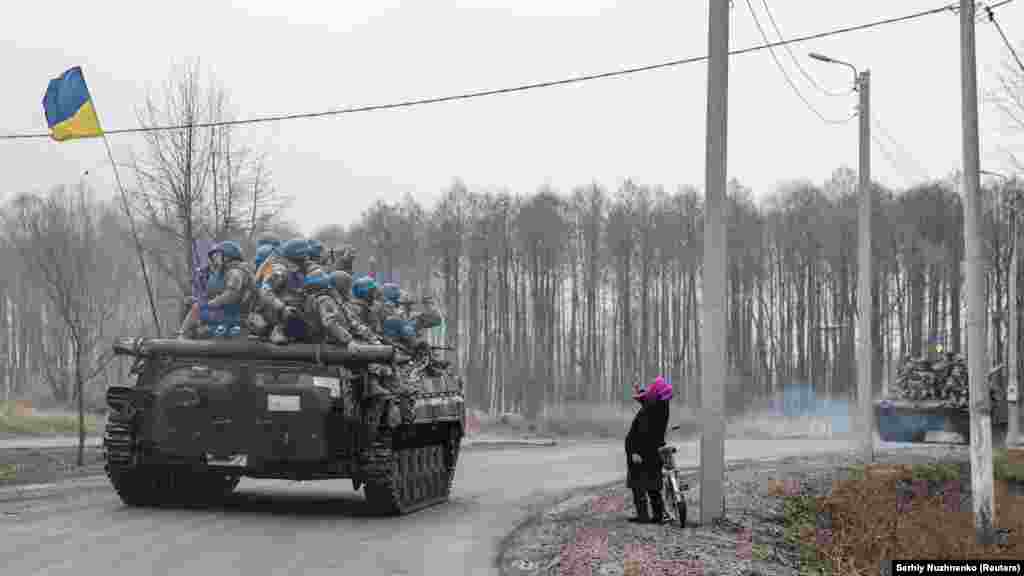 A woman greets Ukrainian troops as they enter a recaptured town in the northern Chernihiv region on April 2, 2022.