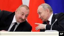 Russian President Vladimir Putin (right) speaks with Azerbaijani President Ilham Aliyev. (file photo)