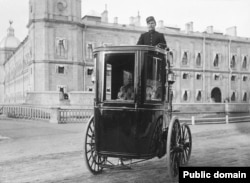 Russian engineer Hippolyte Romanov demonstrates an electric carriage of his own invention outside Gatchina Palace, near St. Petersburg, in the early 1900s.