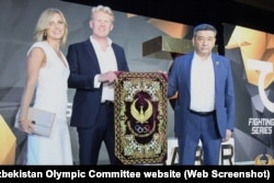 Ross Connon (center) poses at the presentation of Umarov's 7Saber brand in Tashkent on June 26, 2021.