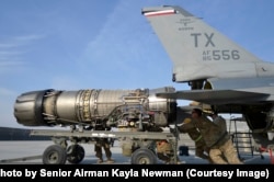 Ground staff pull the engine out of an F-16 at Bagram Airfield in Afghanistan in 2014.