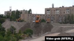 Dump trucks at the Dastan City construction site in early June. RFE/RL observed at least two trucks leaving the site and entering the territory of the sand quarry previously operated by Kum-Shagyl that authorities seized in February.