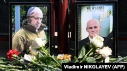 Portraits of Yevgeny Prigozhin (left)) and Dmitry Utkin, a shadowy figure who managed Wagner's operations and allegedly served in Russian military intelligence, are seen at a makeshift memorial in front of the Wagner office in Novosibirsk on August 24.