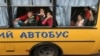 Children gesture as they are evacuated from the Russian-occupied town of Kupyansk town on the outskirts of Kharkiv, on May 30, 2022.