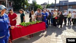 People leave flowers at a makeshift memorial for the shooting victims on June 24.