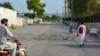 Residents appear on a street partially blocked by barbed wire a day after a Pakistani Army garrison was attacked by a suicide bombing squad in Bannu. 