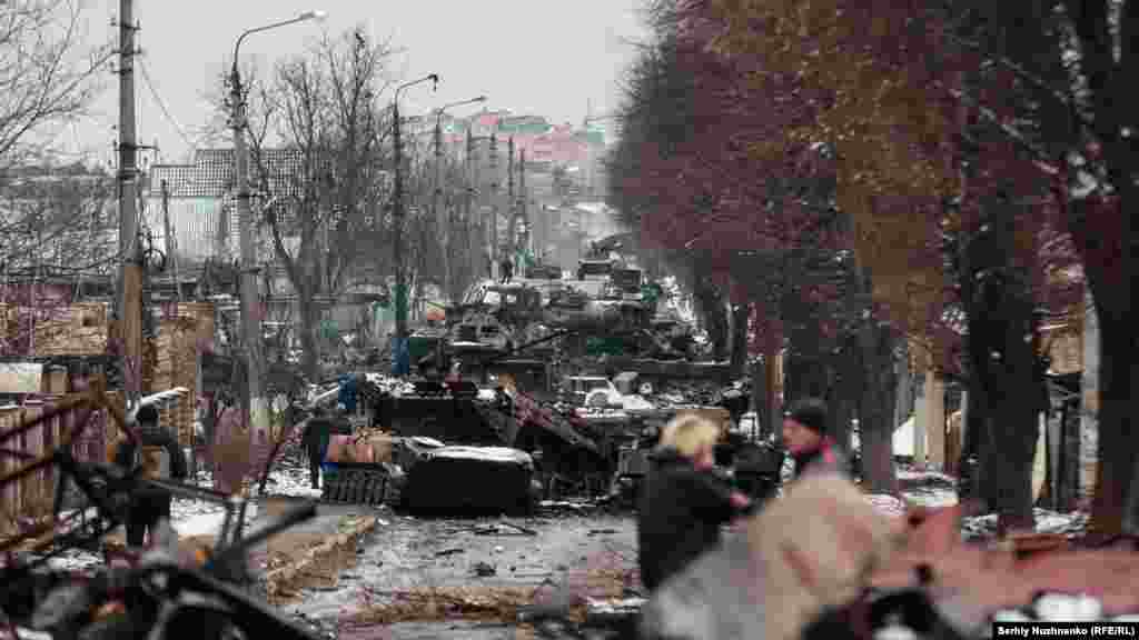 Civilians look at a destroyed Russian armored column in Bucha, near Kyiv, on March 1, 2022. The town was finally captured by Russian troops days after this photo was taken, but they withdrew less than a month later.&nbsp;Following Moscow&rsquo;s retreat, evidence of war crimes emerged in Bucha, drawing international condemnation.