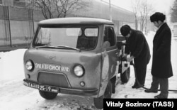 Soviet test-drivers plug in an “electromobile” based on the chassis of an UAZ truck in 1974.