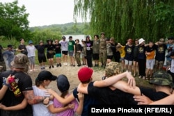 After a session of kayaking, campers and instructors jump up and down chanting “Together to the end” during a summer rain.