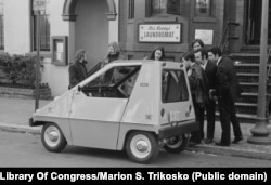 A crowd gathers around a CitiCar in February 1974 in an unspecified American city. The 600-kilogram vehicle began to be produced that year as the oil crisis peaked. A total of 4,444 units of the car were made before it was phased out in 1977.