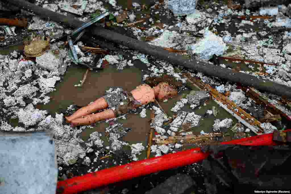 A doll lies on the ground near a damaged residential area in Kyiv.