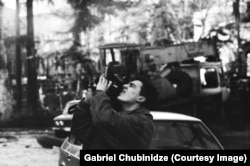 A cameraman records in front of the Georgian parliament.