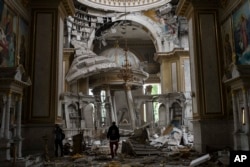 Church personnel inspect damage at the Transfiguration Cathedral in Odesa, Ukraine, on July 23, 2023, following Russian missile attacks.