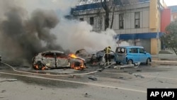 In video released by Russia's Emergencies Ministry on December 30, firefighters extinguish burning cars after an alleged strike in Belgorod.