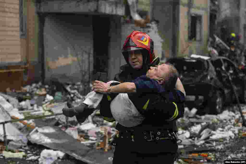 A firefighter carries an injured man from his damaged home in Kyiv.