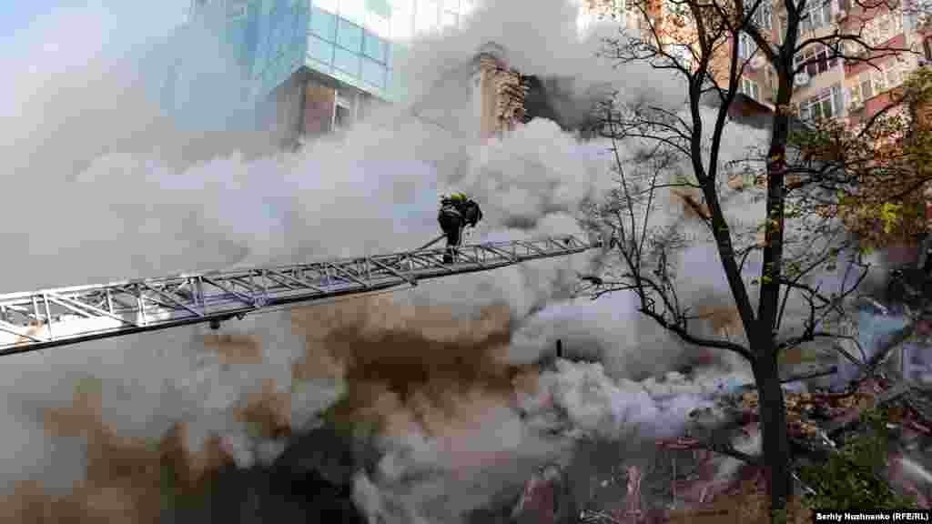 A firefighter battles a blaze after a Shahed suicide drone attack in Kyiv on October 17, 2022.&nbsp;