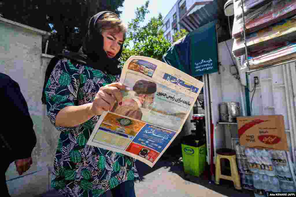 An Iranian woman reads a newspaper with a front-page report on the crash. &nbsp;