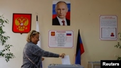 A woman casts her ballot at a polling station during elections held by the Russian-installed authorities in Donetsk on September 9.