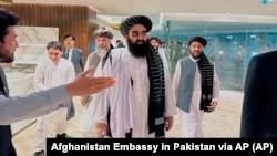 The Taliban-appointed Foreign Minister Amir Khan Muttaqi (center) walks with other officials after arriving in Islamabad for talks with Pakistani officials in May. 