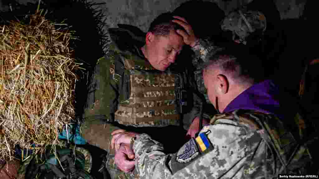 Oleksandr, a military chaplain, blesses a Ukrainian soldier in the northeastern Kharkiv region on April 24, 2022.