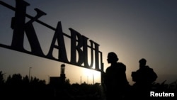 Taliban soldiers stand in front of a sign at the international airport in Kabul. (file photo)