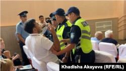 Police escort activist Eldos Dosanov out during public discussions in Semey on the construction of a nuclear power plant on August 8.