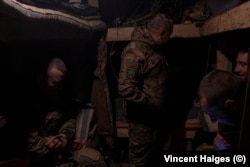 Soldiers from Ukraine's 22nd Mechanized Brigade in their dugout as a Russian Lancet drone flies above.