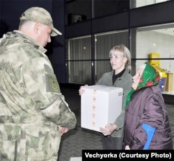 A pensioner hands over a batch of socks to the Storm Gladiators.