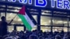 A local man waves a Palestinian flag with a message reading "Daghestan stands by you" during a pro-Palestinian rally at the Makhachkala airport after the arrival of a scheduled flight from Tel Aviv on October 29. 