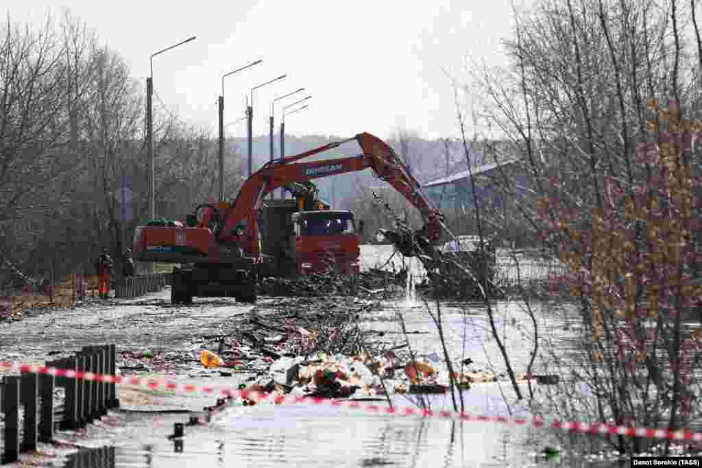 Emergency workers clear logjams on the Malo-Chausovsky Bridge across the Tobol River on April 15 in Kurgan. The region&#39;s governor, Vadim Shumkov, warned of a &quot;colossal&quot; amount of water heading toward the city of Kurgan, which has already experienced power cuts and evacuations. Shmukov said the Tobol River could see water levels rise to 11 meters, double the level where it breaks its banks in some places along its course.