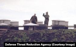 Two unidentified people wearing hazmat equipment at a WMD production site in Ukraine in 1996.