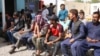 Afghans expelled from Iran wait outside the office of the International Organization of Migration in the western Afghan province of Herat. (file photo)