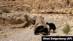 An ultra-Orthodox Jewish man inspects the debris of what is believed to be an intercepted Iranian missile near the city of Arad, southern Israel, on April 28, 2024. 