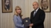 Bulgarian President Rumen Radev (right) hands a mandate to form a government to Goritsa Grancharova-Kozhareva in Sofia on August 9.