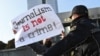 Police officers restrain a protester during a rally of journalists against a new media bill in front of the parliament building in Baku in December 2021.